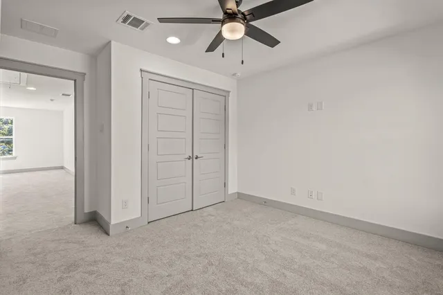 an empty room with chandelier fan