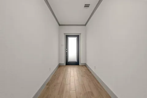 a view of a hallway with wooden floor