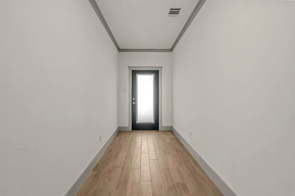 a view of a hallway with wooden floor