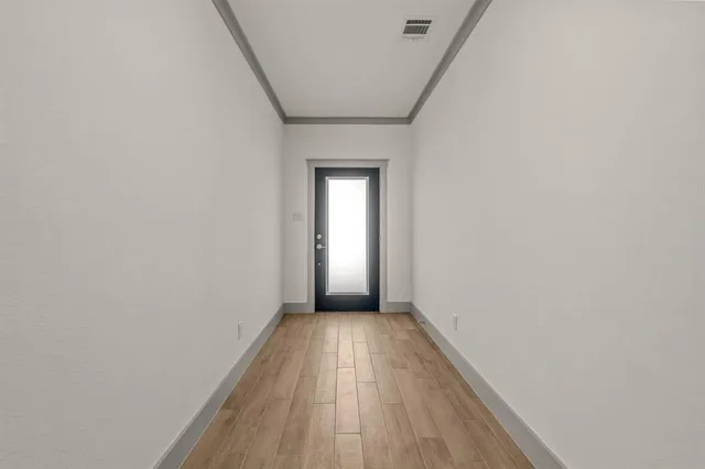 a view of a hallway with wooden floor