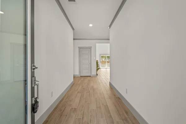 a view of a hallway with wooden floor