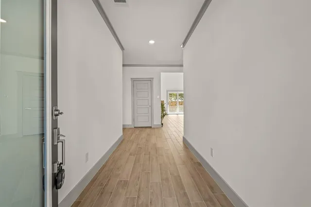 a view of a hallway with wooden floor