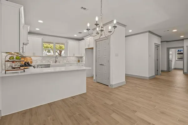 a view of a kitchen with a sink dishwasher a refrigerator and wooden floor