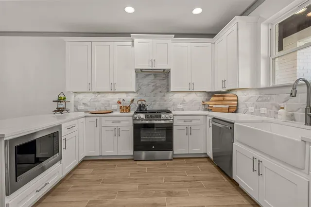 a kitchen with granite countertop white cabinets and white stainless steel appliances
