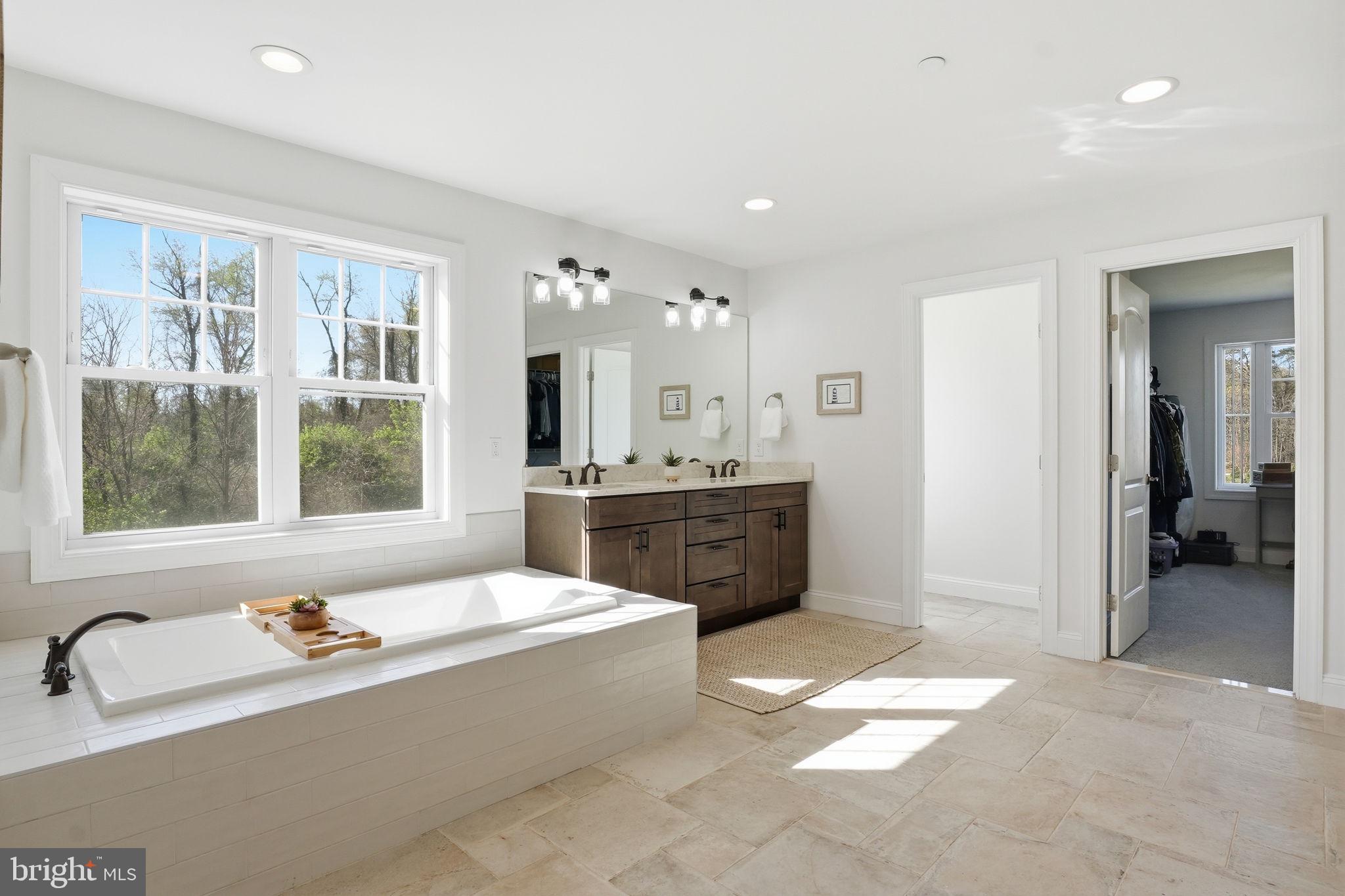 3177 Patuxent River Road Davidsonville, MD 21035 - Photo 24 of 51 a spacious bathroom with a tub a double vanity sink a mirror and a bathtub