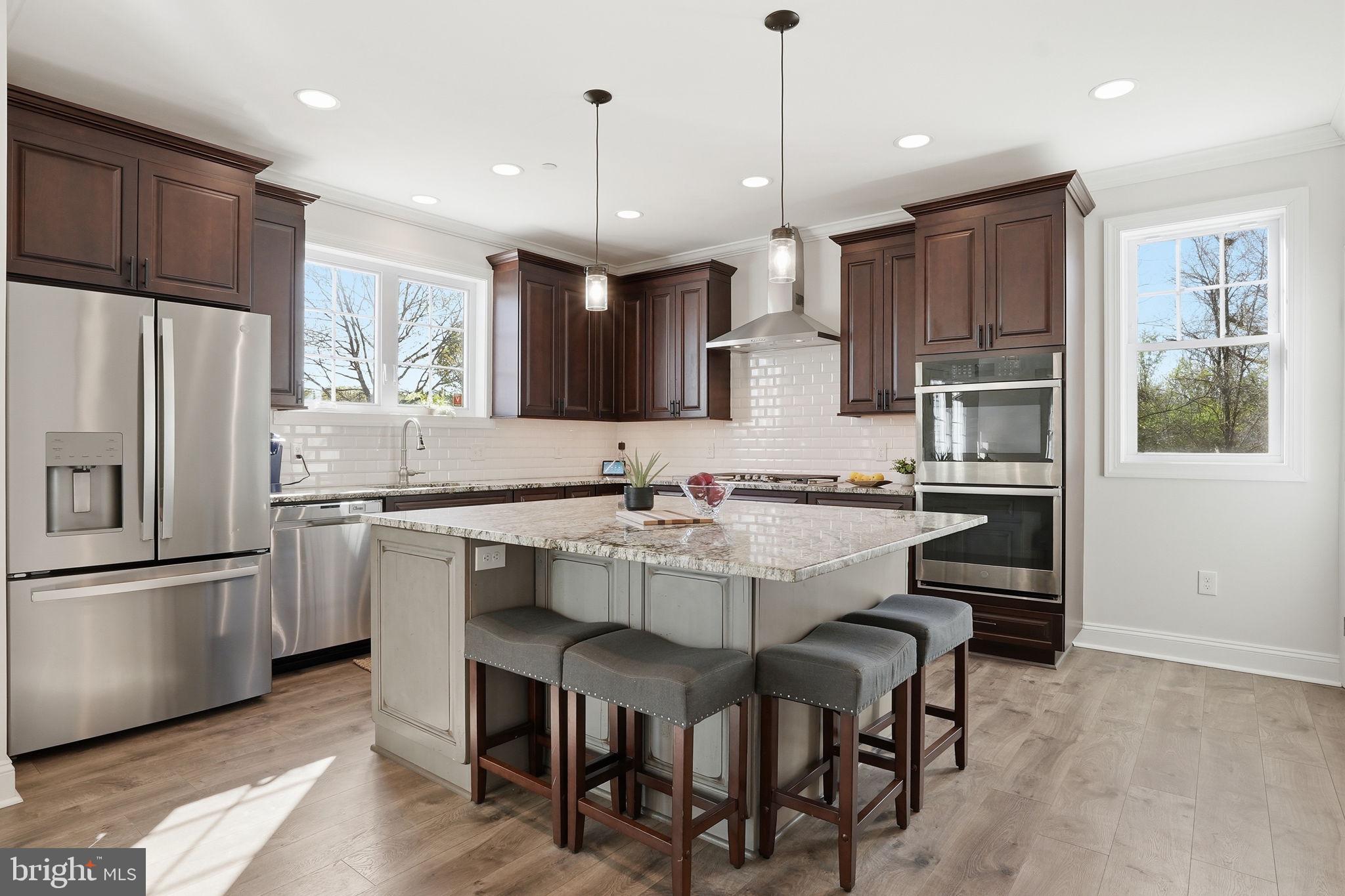 3177 Patuxent River Road Davidsonville, MD 21035 - Photo 9 of 50 a kitchen with stainless steel appliances granite countertop a table chairs sink refrigerator and microwave