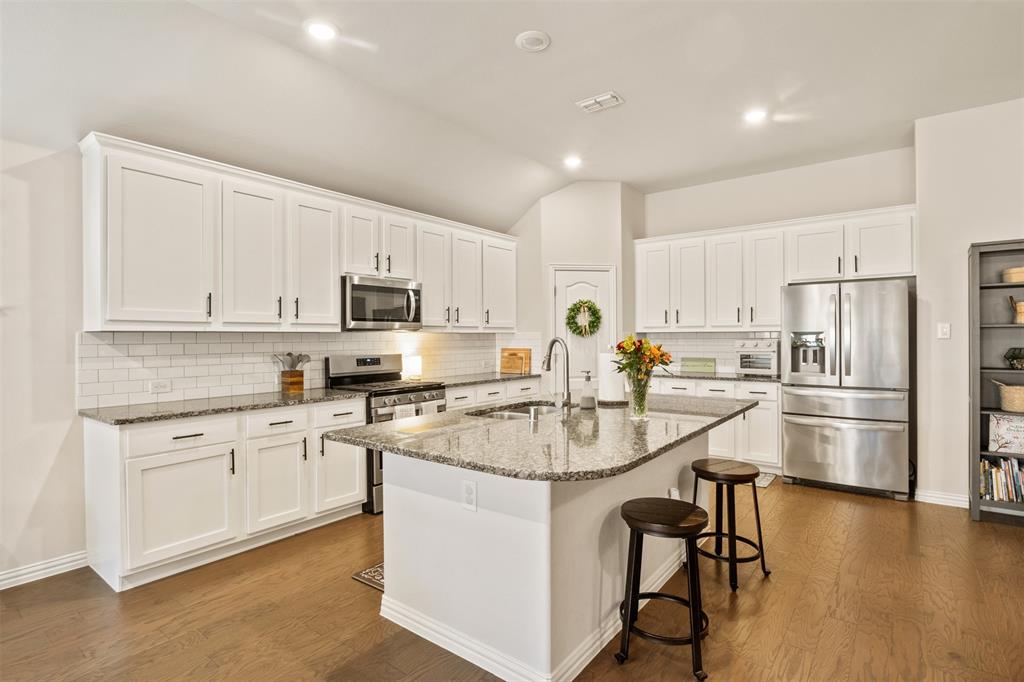 317 Timberline Drive Midlothian, TX 76065 - Photo 9 of 30 a kitchen with stainless steel appliances granite countertop a refrigerator a stove a sink a dining table and chairs