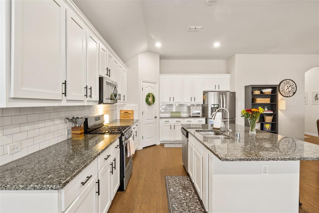 317 Timberline Drive Midlothian, TX 76065 - Photo 10 of 30 a kitchen with stainless steel appliances granite countertop a sink a stove and a wooden cabinets