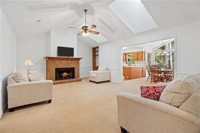 a living room with furniture a fireplace and a chandelier