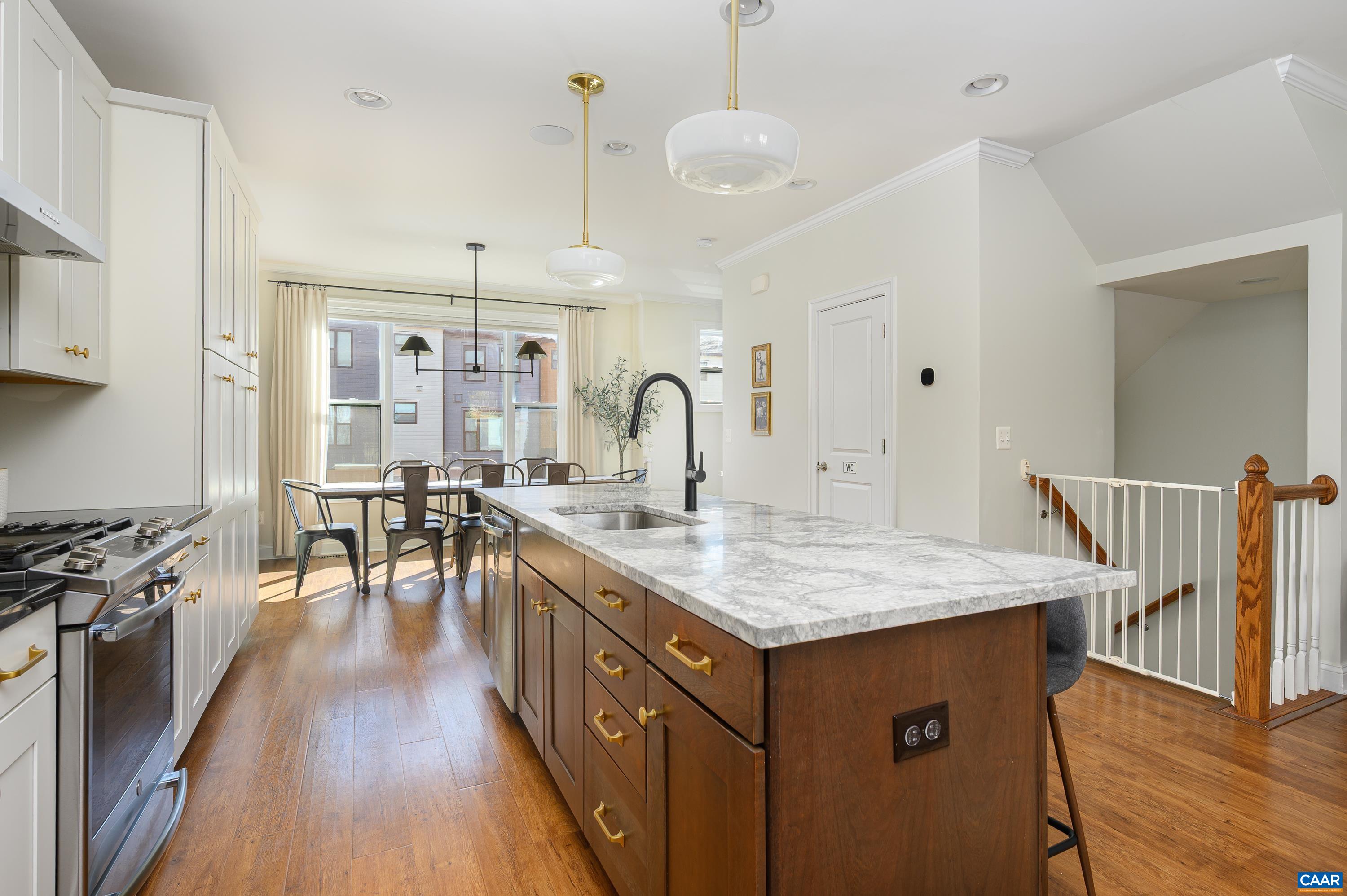 147 Junction Lane Charlottesville, VA 22902 - Photo 11 of 30 a kitchen with a stove a sink a dining table and chairs with wooden floor