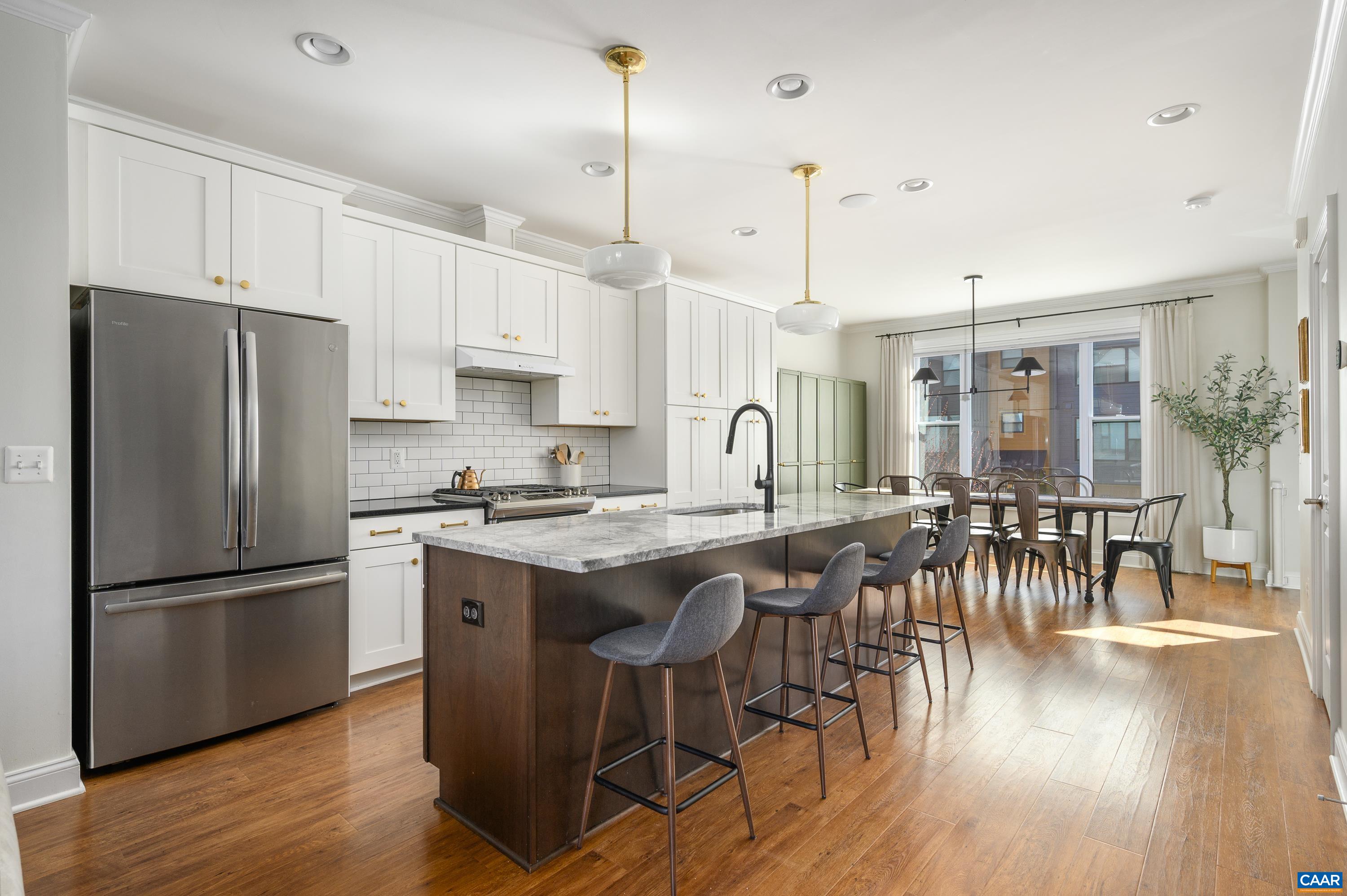 147 Junction Lane Charlottesville, VA 22902 - Photo 9 of 30 a kitchen with stainless steel appliances granite countertop a table chairs stove a refrigerator a sink a dining table and chairs with wooden floor