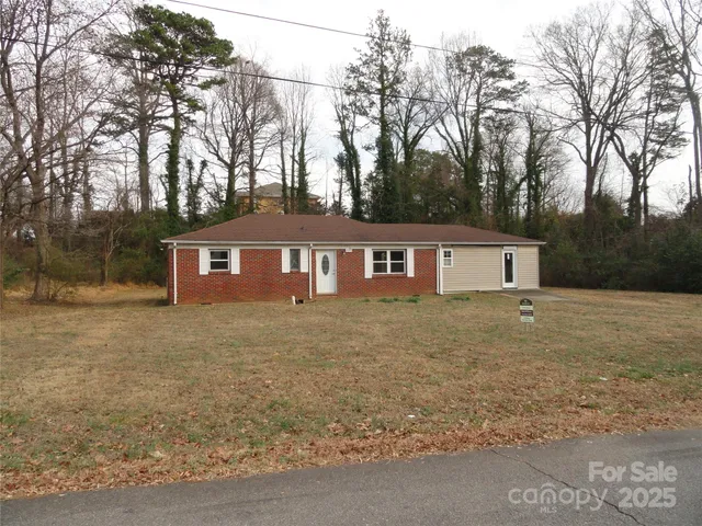 a front view of a house with yard and trees