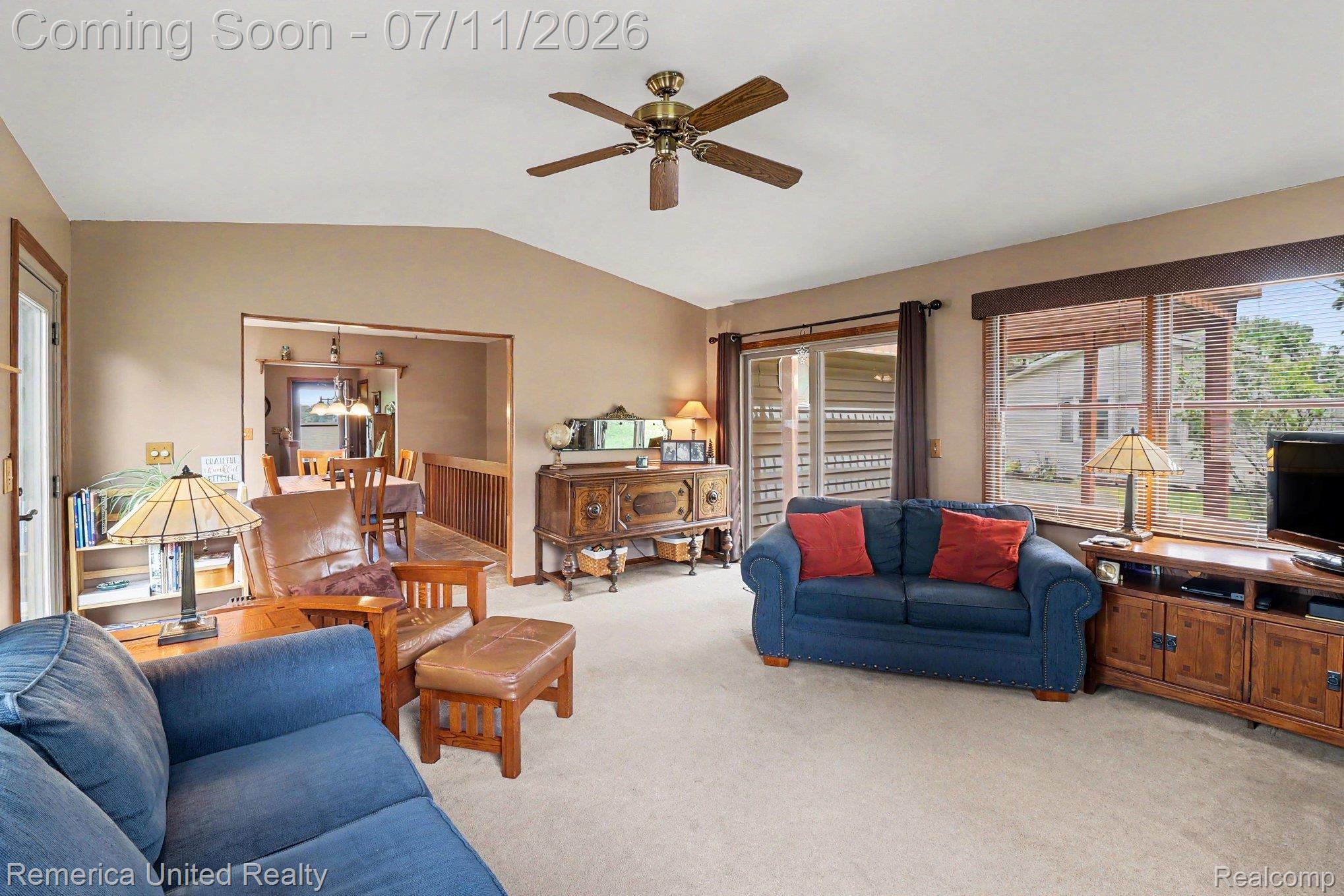 136 Endicott Howell, MI 48843 - Photo 5 of 28 Inviting living area featuring vaulted ceilings, a ceiling fan fixture, and plush carpeting