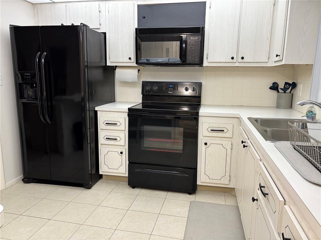 4750 Cove Circle, Unit 904 St. Petersburg, FL 33708 - Photo 11 of 37 a kitchen with a refrigerator stove and cabinets