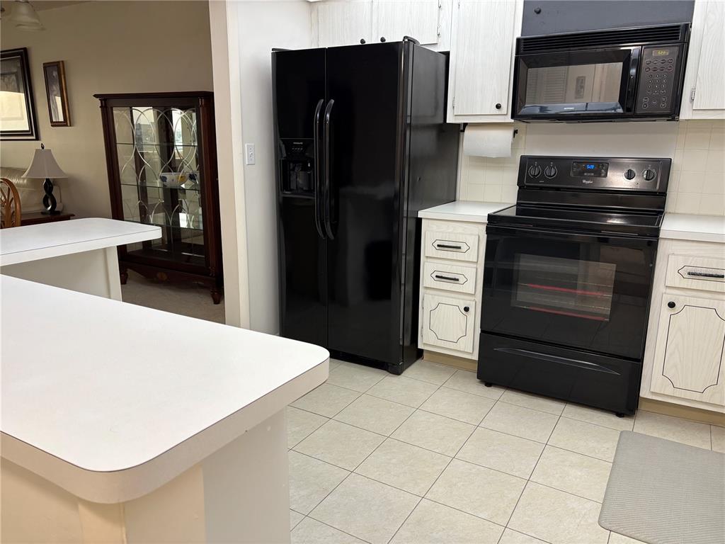 4750 Cove Circle, Unit 904 St. Petersburg, FL 33708 - Photo 13 of 37 a kitchen with a refrigerator stove and cabinets