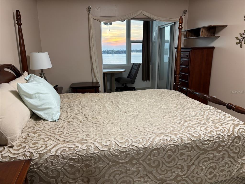 4750 Cove Circle, Unit 904 St. Petersburg, FL 33708 - Photo 14 of 37 a bedroom with a bed wooden floor and a window