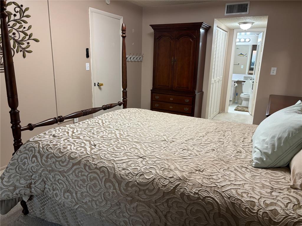 4750 Cove Circle, Unit 904 St. Petersburg, FL 33708 - Photo 15 of 37 a bedroom with a bed and a mirror