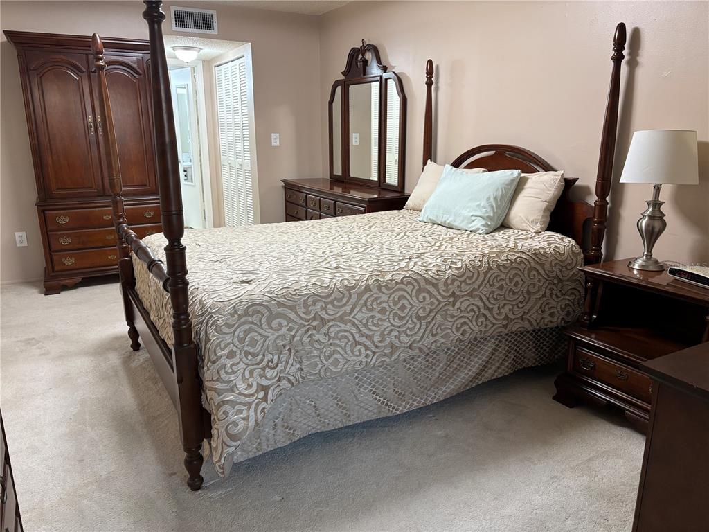 4750 Cove Circle, Unit 904 St. Petersburg, FL 33708 - Photo 16 of 37 a bedroom with a bed and a dresser