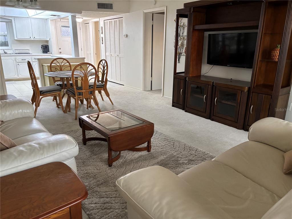 4750 Cove Circle, Unit 904 St. Petersburg, FL 33708 - Photo 2 of 37 a living room with furniture and a flat screen tv