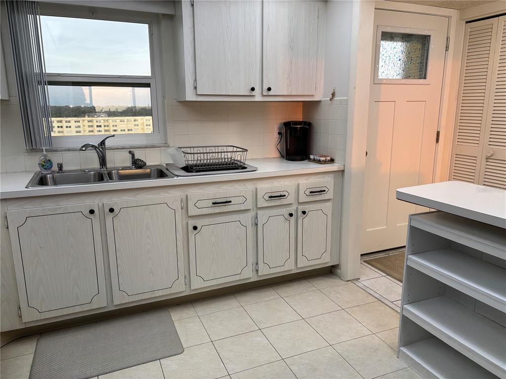 4750 Cove Circle, Unit 904 St. Petersburg, FL 33708 - Photo 9 of 37 a kitchen with white cabinets and sink