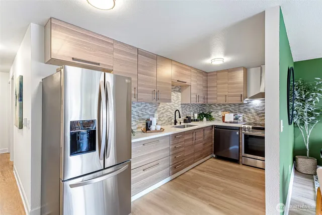 a kitchen with stainless steel appliances a refrigerator sink and cabinets
