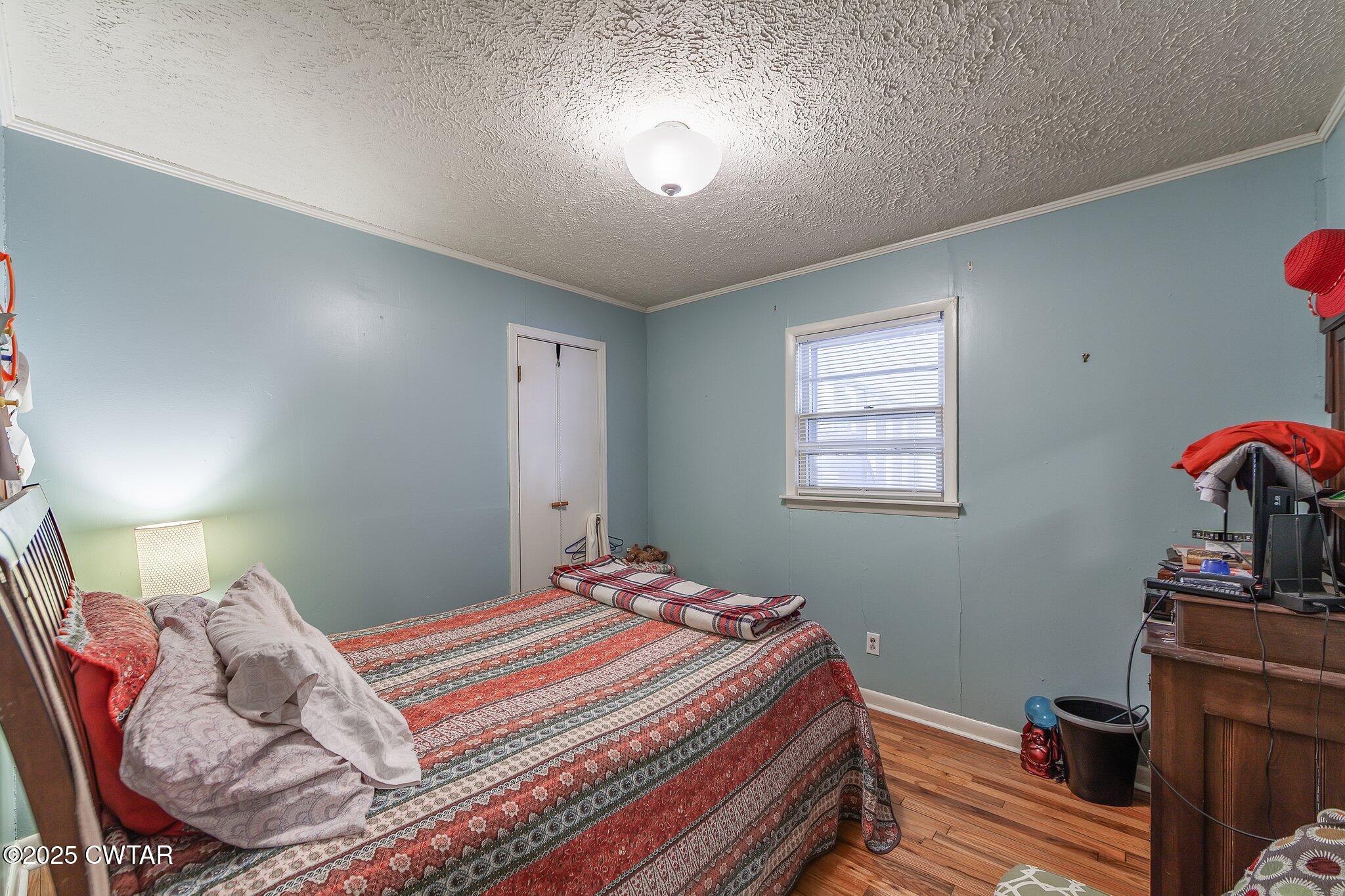 196 Pierce Road Beech Bluff, TN 38313 - Photo 10 of 63 a bedroom with a bed and a bookshelf with wooden floor