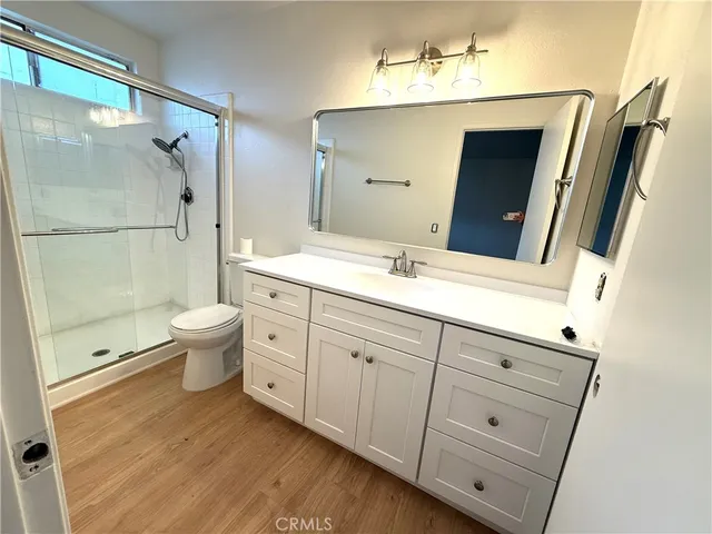a bathroom with a double vanity sink a toilet and a mirror