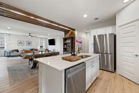 a kitchen that has a lot of cabinets a sink and a refrigerator