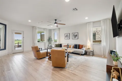 a living room with furniture flat screen tv and window