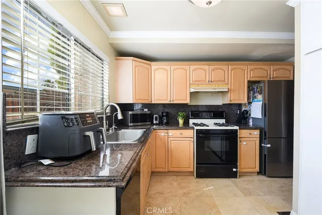 a kitchen with stainless steel appliances granite countertop a stove a sink and a microwave