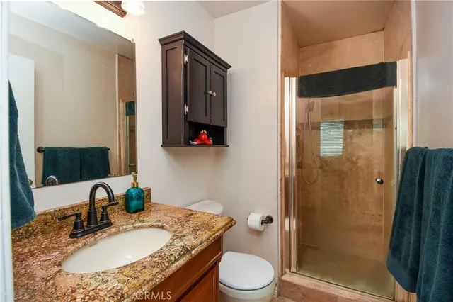 a bathroom with a granite countertop sink toilet and shower