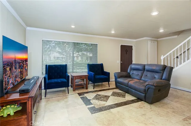 a living room with furniture a rug and a flat screen tv