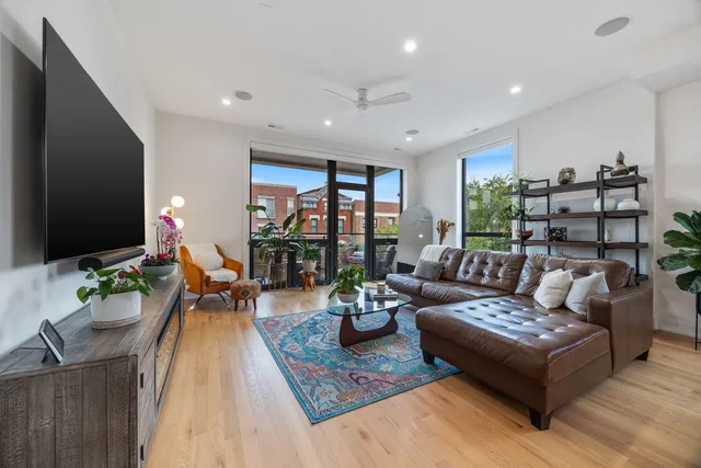 a kitchen with kitchen island a sink a stove a refrigerator and white cabinets with wooden floor