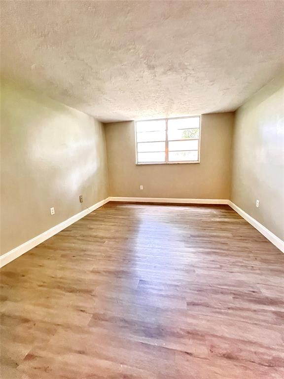 7000 Northwest 17th Street, Unit 109 Plantation, FL 33313 - Photo 14 of 21 wooden floor in an empty room with a window