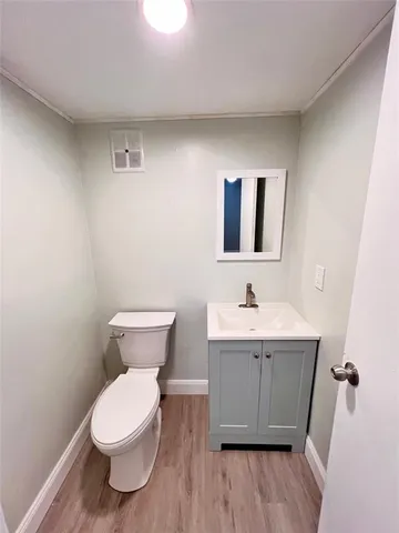 a bathroom with a toilet a sink and mirror