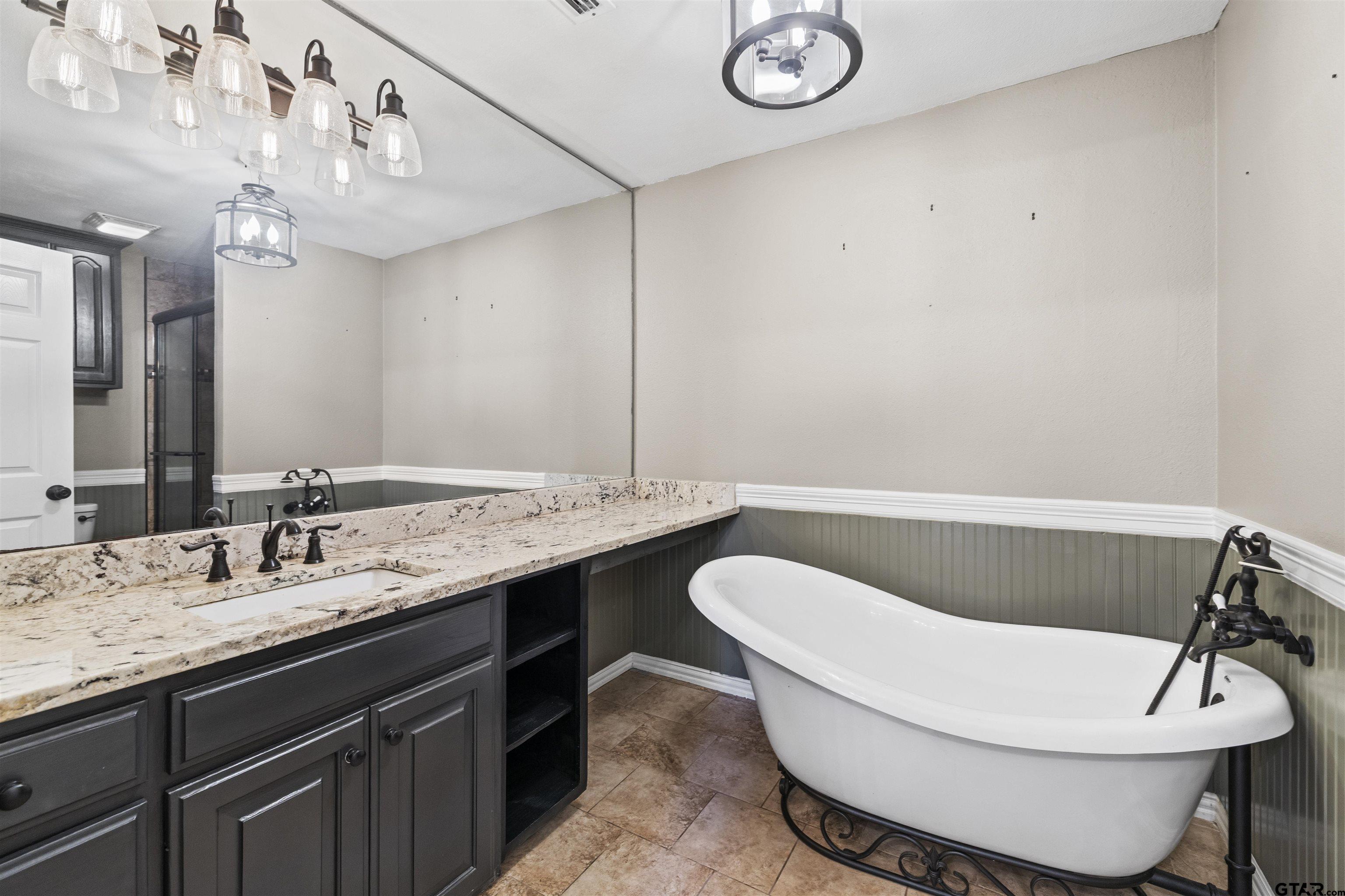 5066 Bob O Link Road Gilmer, TX 75645 - Photo 20 of 34 a bathroom with a double vanity sink and a bathtub