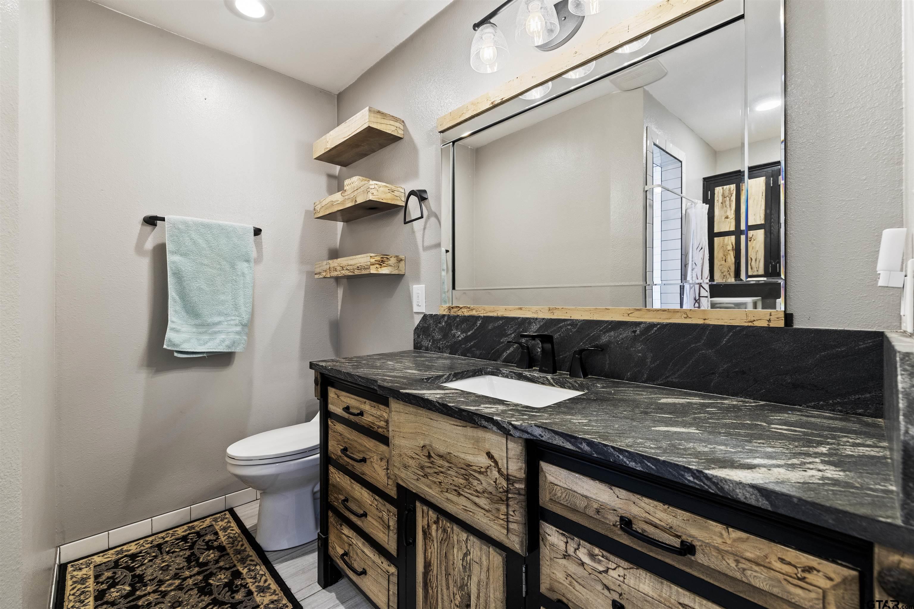 5066 Bob O Link Road Gilmer, TX 75645 - Photo 27 of 34 a bathroom with a granite countertop sink and a toilet
