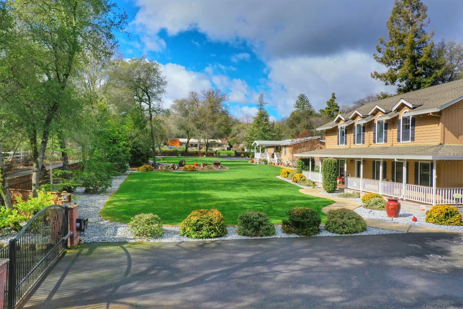 3785 Many Oaks Lane Shingle Springs, CA 95682 - Photo 1 of 1 a front view of a house with a garden and trees