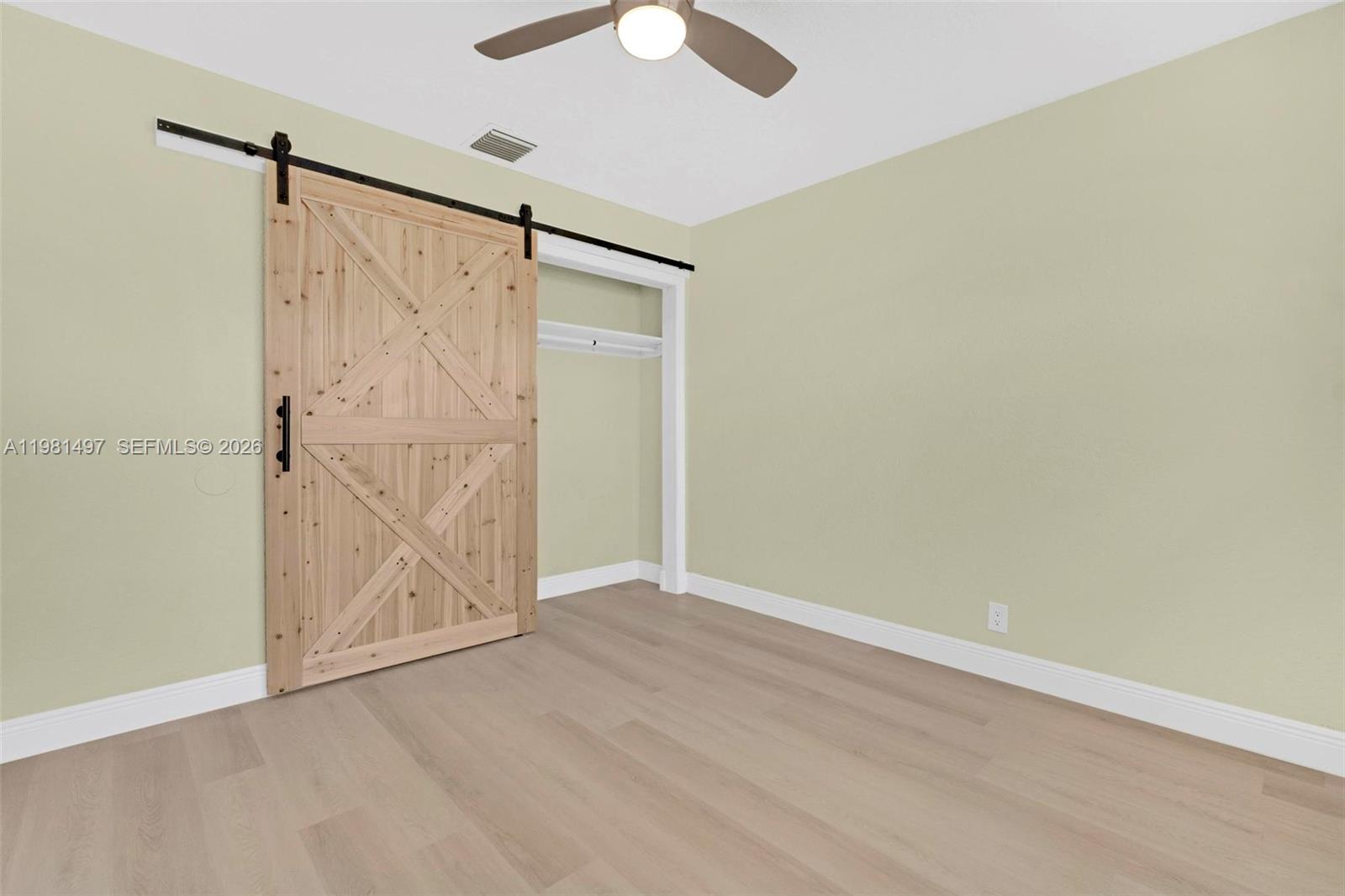 369 Phippen Waiters Road, Unit 2 Dania Beach, FL 33004 - Photo 16 of 18 an empty room with wooden floor closet and windows