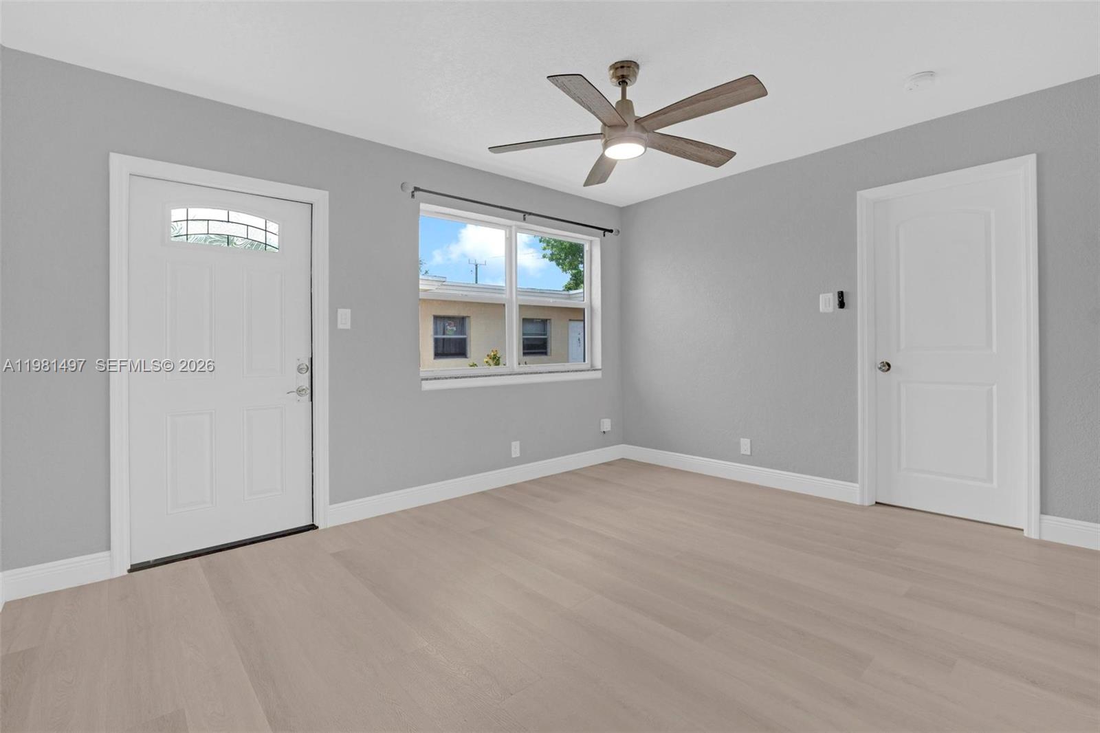 369 Phippen Waiters Road, Unit 2 Dania Beach, FL 33004 - Photo 2 of 18 wooden floor in an empty room with a window