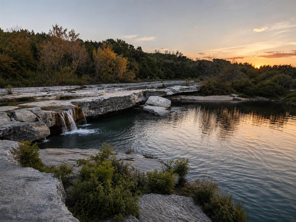 7225 Ranchito Drive Austin, TX 78744 - Photo 39 of 40 McKinney Falls.
Natural rock ledges and a gentle waterfall frame the scenic river views at sunset.