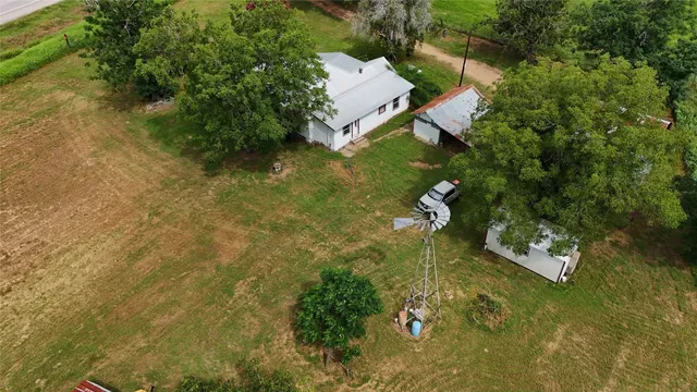 an aerial view of residential houses with outdoor space and trees