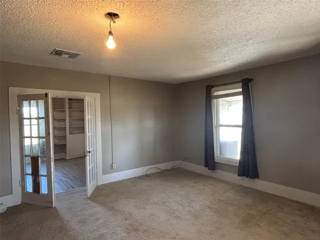 an empty room with windows and closet