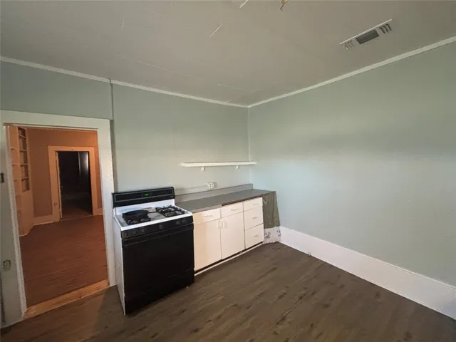 a kitchen with wooden floor and stainless steel appliances