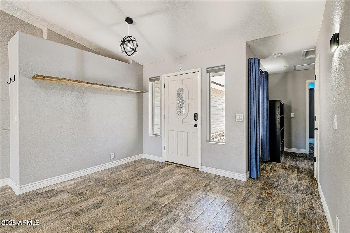 7624 North Citrus Road Waddell, AZ 85355 - Photo 7 of 57 a view of a hallway with wooden floor and a chandelier fan