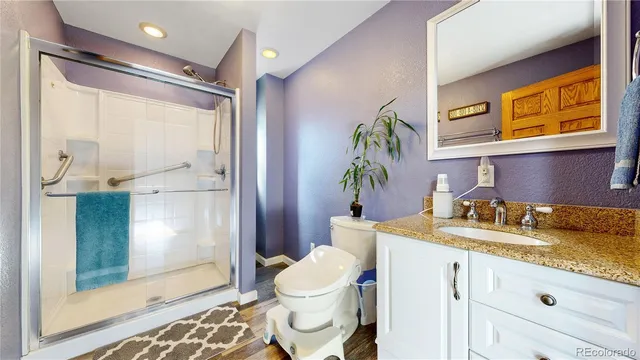 a bathroom with a granite countertop sink toilet and shower