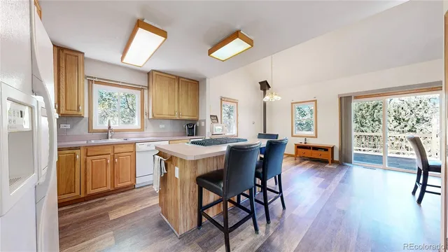 a kitchen with granite countertop wooden floors and wooden cabinets