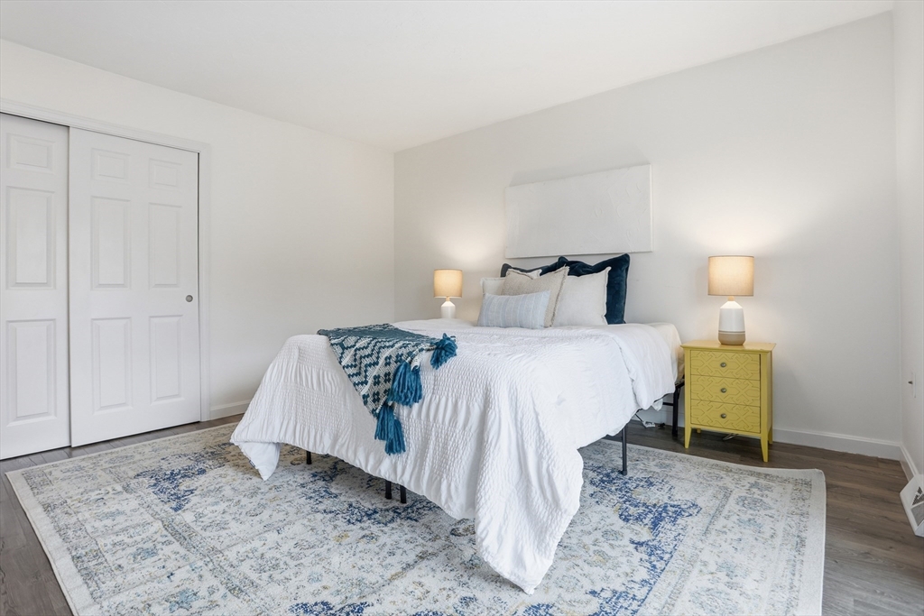 425 Main Street, Unit 22C Hudson, MA 01749 - Photo 12 of 23 a bedroom with a bed and wooden floor