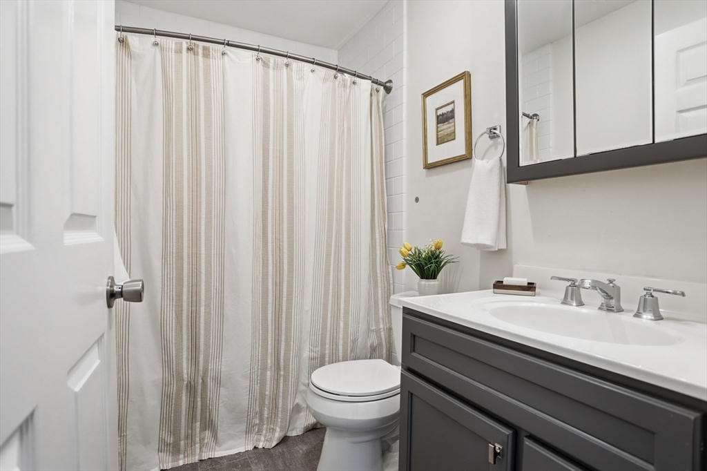425 Main Street, Unit 22C Hudson, MA 01749 - Photo 14 of 23 a bathroom with a sink a toilet and shower curtain