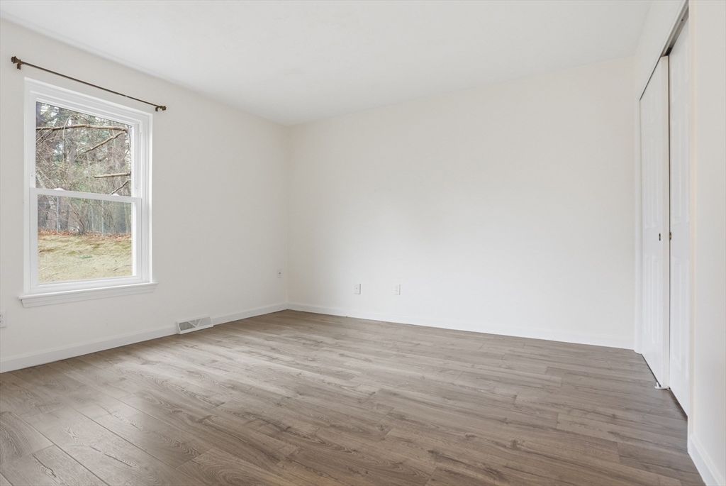425 Main Street, Unit 22C Hudson, MA 01749 - Photo 15 of 23 a view of an empty room with wooden floor and a window